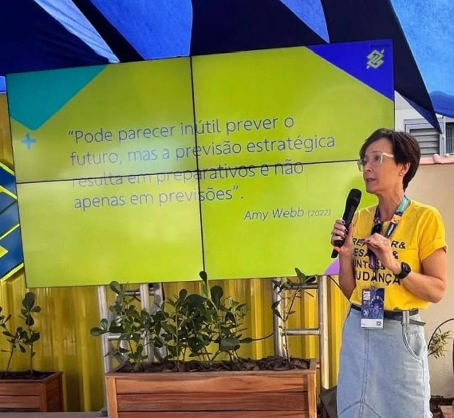Inês palestrando sobre foresight, com citação de Amy Webb ao fundo
